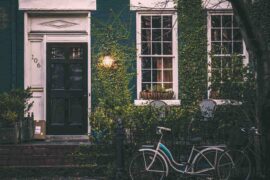 close up of ivy covered house with bicycle - how to price a green home
