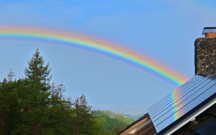 Solar panels on house with rainbow