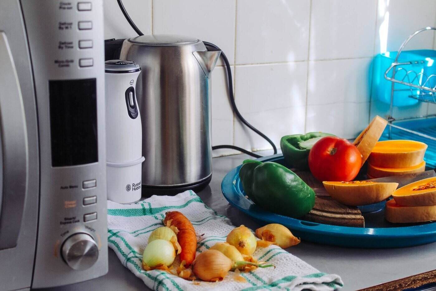 microwave, hand blender and kettle beside veggies - tips for appliance repair
