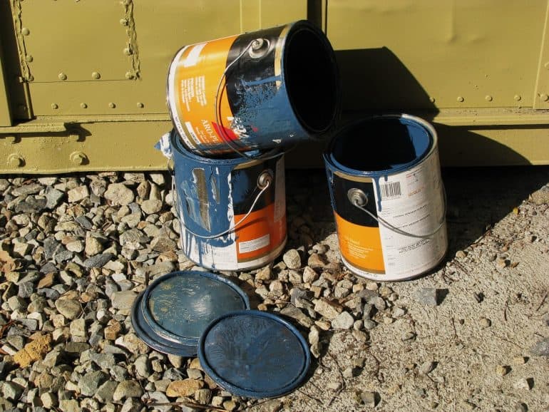 Three paint cans sitting on ground