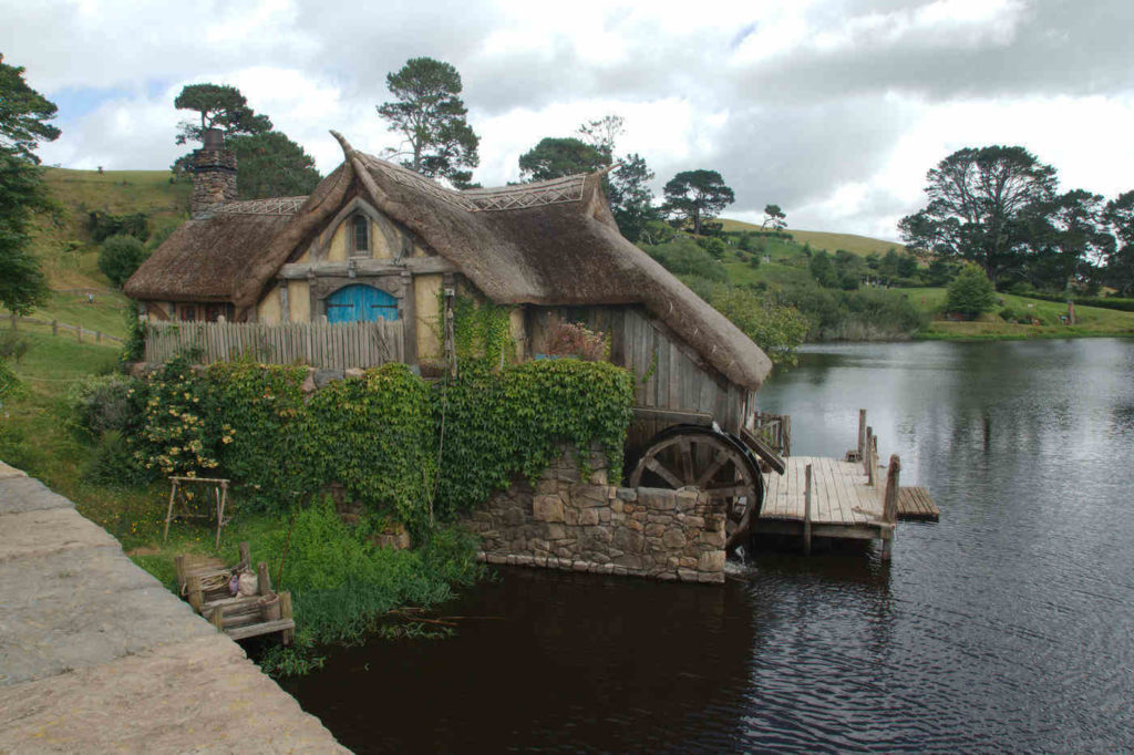 thatched roof house with watermill - the basics of living off the grid