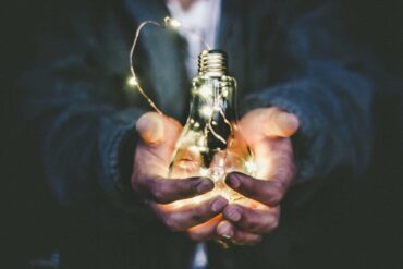 man with lightbulb in outstretched hand - how to save money and gain energy independence