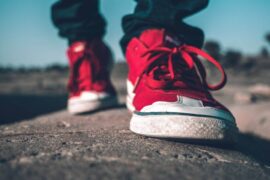 close up of person wearing red shoes while walking - how to live green on the go