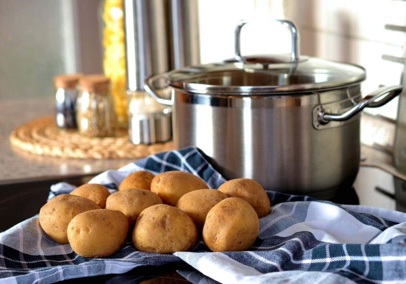 covered pot on stove beside potatoes - tips for eco-friendly cooking