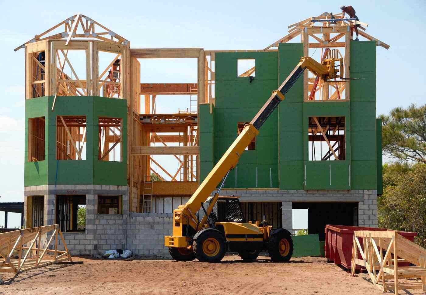 crane in front of house under construction - modular homes vs stick-built homes
