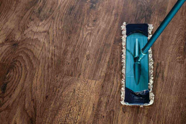 top view of dry mop on wooden floor - tips for cleaning your house the eco-friendly way