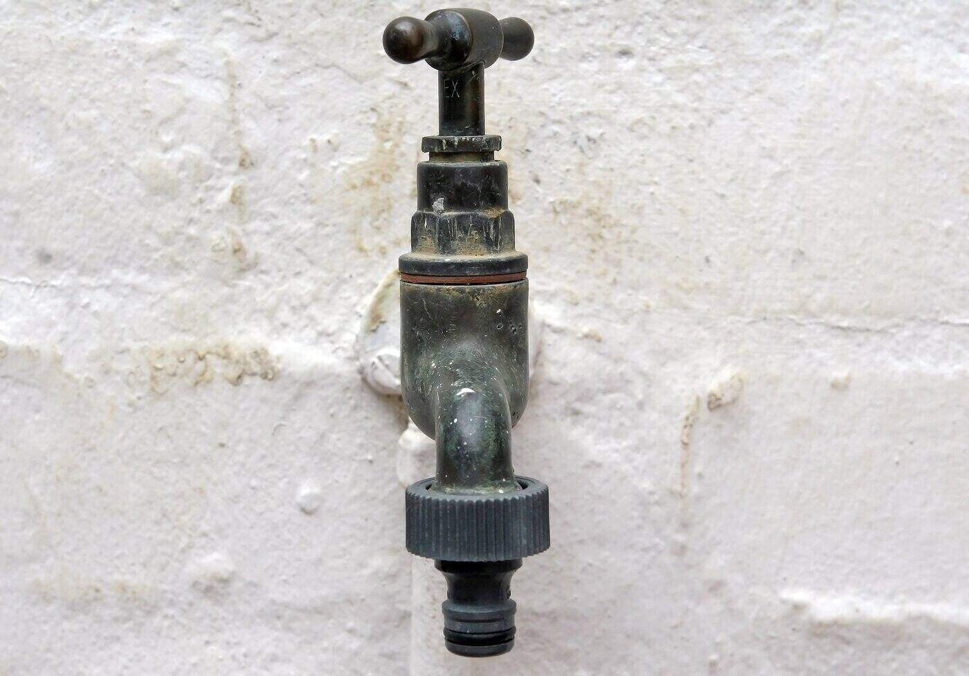 spigot on white wall - exterior home maintenance tasks to do before fall