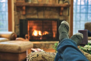 feet up on ottoman in front of fire - energy-efficient ways to heat your home over winter