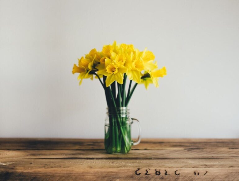 glass jar with daffodils - 5 eco-friendly tips for spring cleaning and maintenance