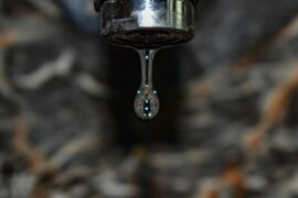 close up of water dripping from tap - 6 reasons why your sink drain smells bad