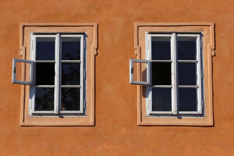 pair of windows in orange wall - which energy efficient windows cut down on energy bills