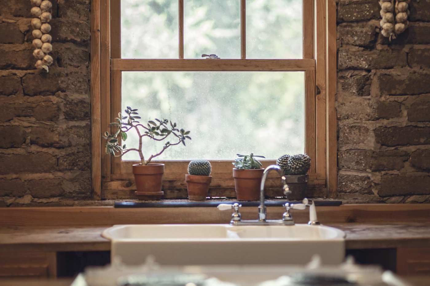 wooden window over farmhouse sink - how energy efficient windows cut down on energy bills