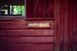shed wall with happy house sign - 7 smart ways to use a backyard shed